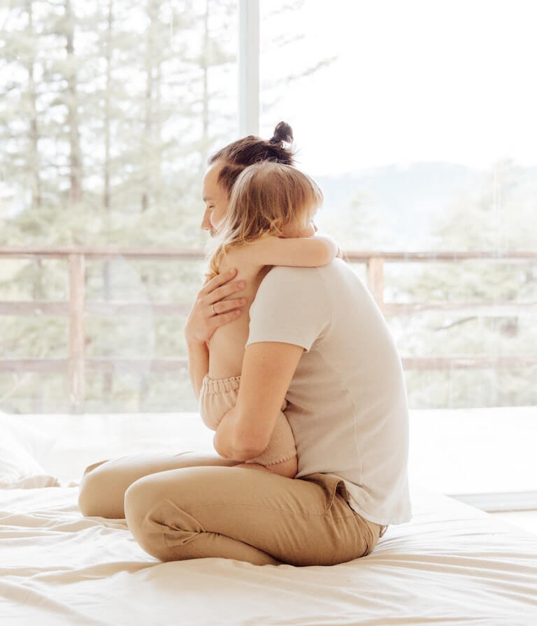 A parent hugging his baby