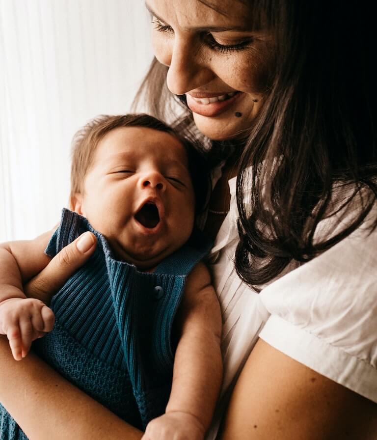 Smiling mother holding her cute baby